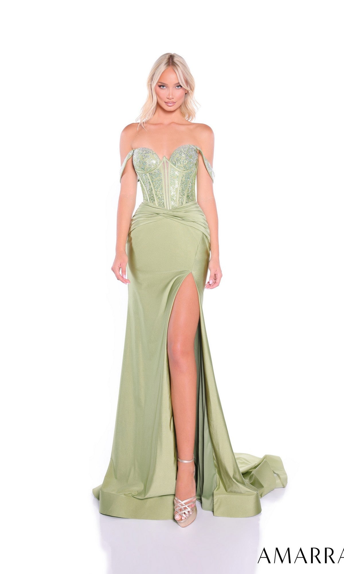 A woman wears the Amarra 89359 long prom dress in light green, featuring an off-the-shoulder style, embellished corset bodice, high leg slit, and train, posing against a white background.